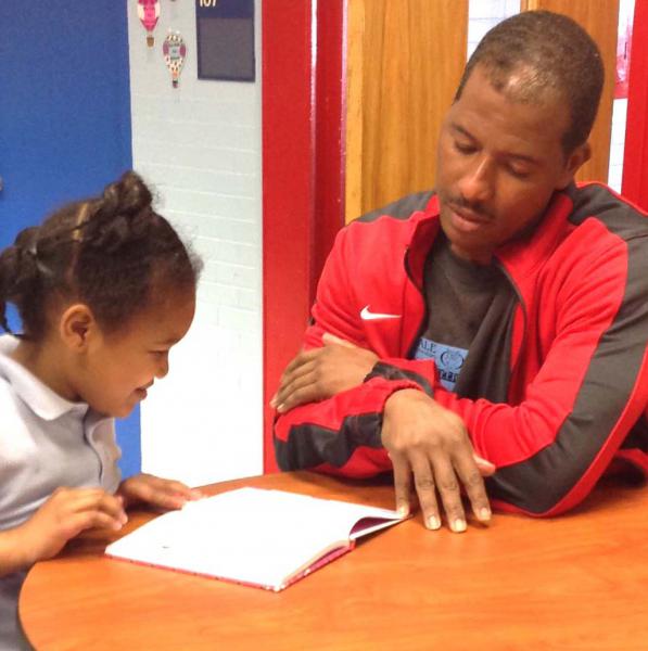 community volunteers reading with a student